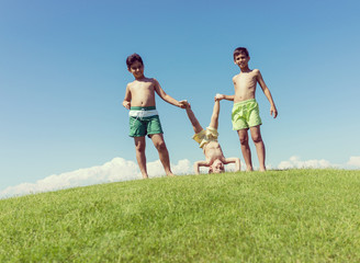 Obraz premium Brothers playing upside down on green meadow