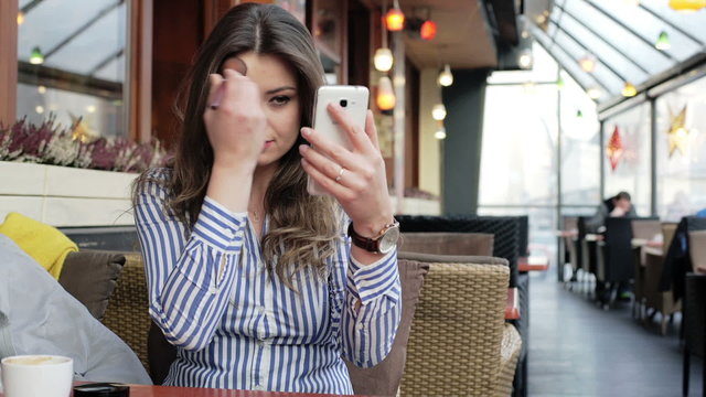 Businesswoman improving her hairstyle while sitting in the outdoor cafe
