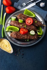 Kebabs with vegetables on the vintage metal plate vertical