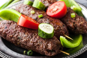 Kebabs with vegetables on the vintage metal plate close-up