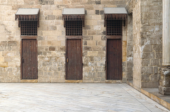 Three doors in a stone wall at the main courtyard in a historic