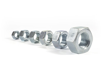 Metal Nuts Lined Up From Smallest To Largest Isolated On White 