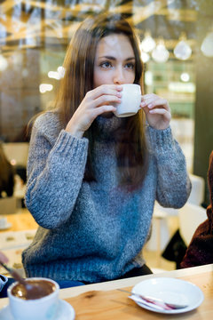 Beautiful young woman drinking coffee at cafe shop.