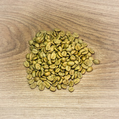 Green coffee beans on a brown background in a light vignette