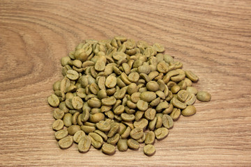 Green coffee closeup beans on a brown background