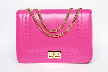 Pink lady's bag with a gold chain on a white background