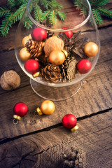 Fototapeta na wymiar Christmas balls, cones and walnuts on a wooden background