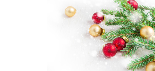 Fir branches and Christmas balls on a white background. Snowing