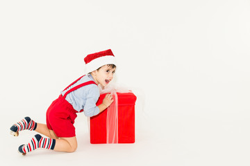 Happy caucasian Xmas toddler opening a big Christmas gift box - isolated on white background