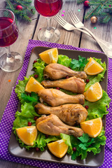 Dish with roasted chicken legs, greens, oranges and wine. Christ