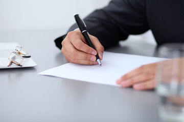Close-up of male hands with pen over document,  business concept