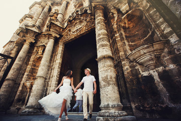 Happy wedding couple walking in old city