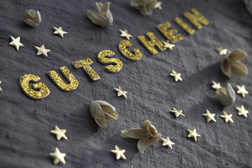 GUTSCHEIN in Gold mit Sternen und Naturmaterialien auf Leinen