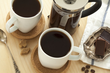 Cups of coffee and chocolate on table