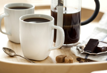 Cups of coffee and chocolate on tray