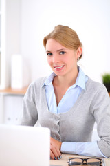 Young blonde business woman with laptop in the office. Business concept.