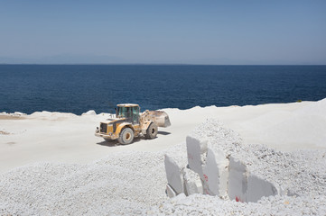 Bulldozer at marble quarry on island