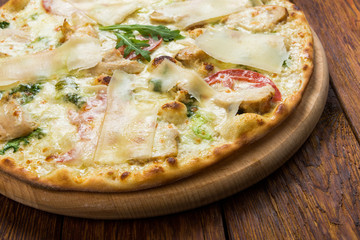 Delicious pizza with chicken, parmesan and fresh arugula