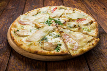 Delicious pizza with chicken, parmesan and fresh arugula