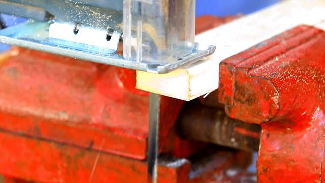 Jigsaw cutting a wooden plank closeup
