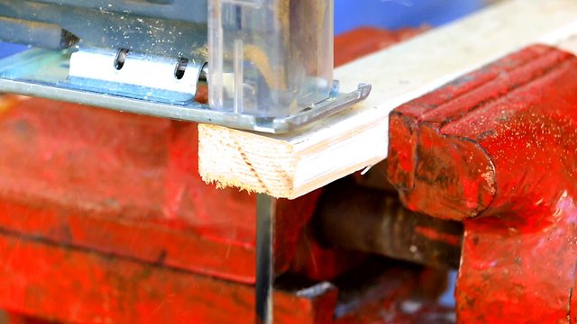 Jigsaw cutting a wooden plank closeup