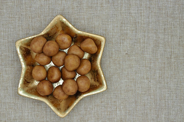 Marzipankartoffeln / Marzipankartoffeln in einer goldenen, sternförmigen Schale auf Jute, Nahaufnahme, Aufsicht, direkt von oben, horizontal mit Textfreiraum