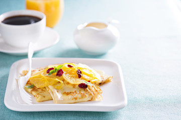 Thin crepes with citrus sauce and dried cranberry