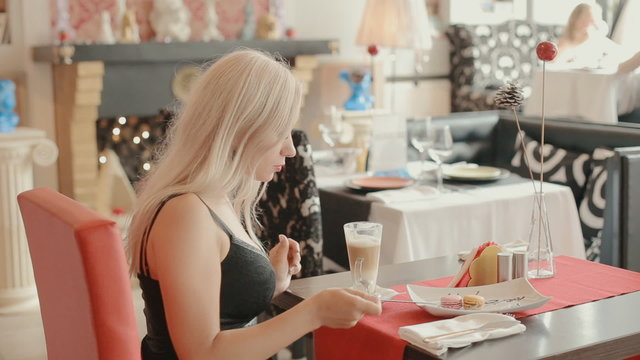 Charming blonde drinking latte in a cafe