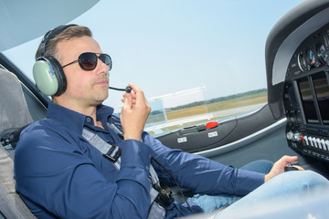 Man in cockpit of aircraft wearing headphones with microphone