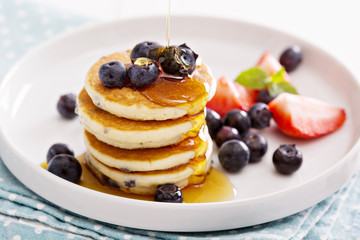 Stack of small pancakes with fresh berries 
