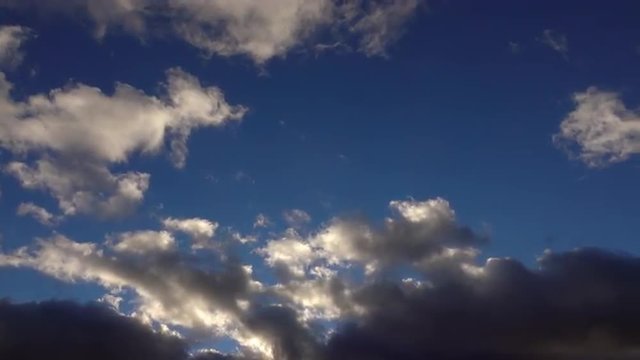 UHD 4K time lapse cloudscape background with lengthwise fast moving clouds over blue sky. Wonderful nature scene. 3840x2160
