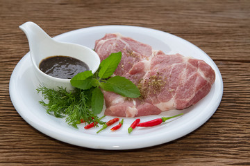 Fresh raw pork with pepper souce on wooden background