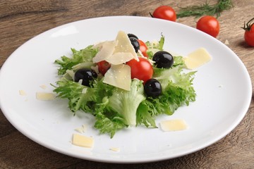 Fresh vegetables salad with tomatoes , olives , parmesan cheese