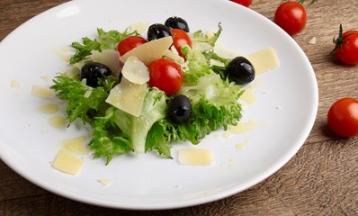Fresh vegetables salad with tomatoes , olives , parmesan cheese