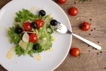 Fresh vegetables salad with tomatoes , olives , parmesan cheese