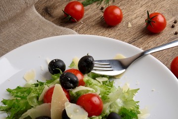 Fresh vegetables salad with tomatoes , olives , parmesan cheese