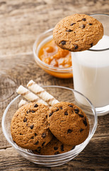 glass of milk and cookie on wooden background