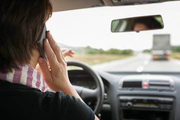 Woman using mobile phone while driving a car