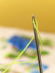 needle eye with green thread macro, shallow depth of field