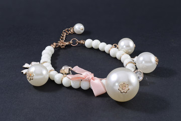 bracelet with pearls and pendants isolated on black