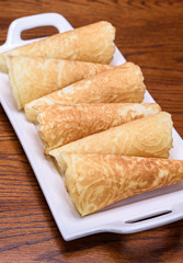 Holiday Krumkake cookies ready to eat on a white serving platter 
