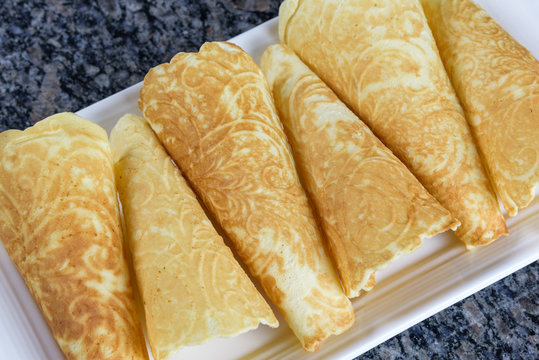 Holiday Krumkake cookies ready to eat on a white serving platter 
