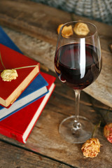 Beautiful composition with glass of wine with old books on table close up