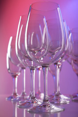 Empty wine glasses on color background