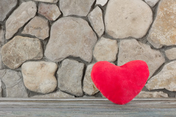 Obraz premium plush red heart on the background of a stone wall, the concept of love and romance. Free space for text. Copy space