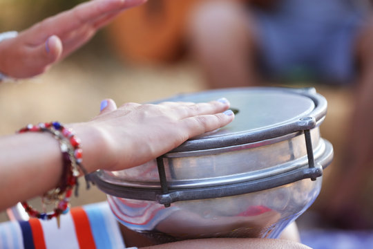 Females hands play a drum, close up