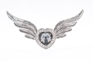 Silver brooch in the form of heart on a white background