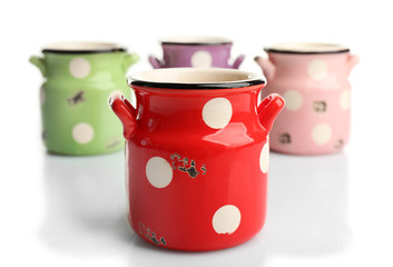 Old colourful milk cans with polka dots, isolated on white