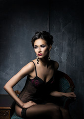 Fototapeta premium Gorgeous young woman in sexy lingerie and stockings posing in a