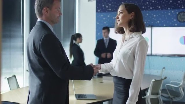 Handshake between Male Manager and Female Office Worker. Shot on RED Cinema Camera.
